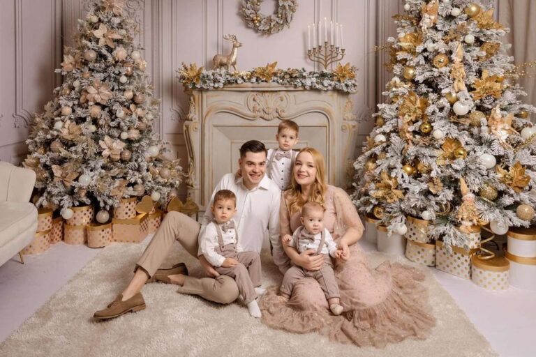 Ședință foto de Crăciun în studio București - familie cu copii și brazi împodobiți cu auriu și crem